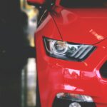 Detailed view of a sleek red sportscar showcasing elegant design and modern headlights.